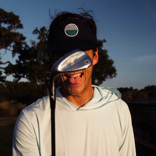 Person holding a golf club with a scenic background